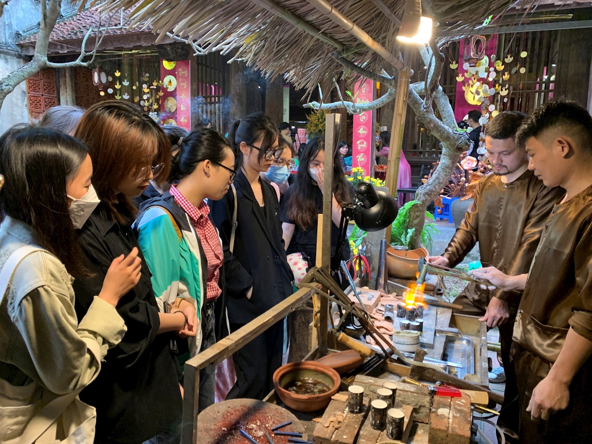 Các bạn trẻ xem nghệ nhân phố Hàng Bạc thao tác nghề truyền thống. Ảnh: Linh Tâm. Các bạn trẻ xem nghệ nhân phố Hàng Bạc thao tác nghề truyền thống. Ảnh: Linh Tâm.