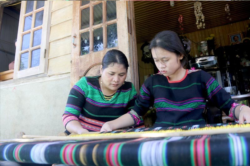 Nghệ nhân H’Bình truyền dạy nghề dệt thổ cẩm cho con gái Trần H’Nhàn Nghệ nhân H’Bình truyền dạy nghề dệt thổ cẩm cho con gái Trần H’Nhàn
