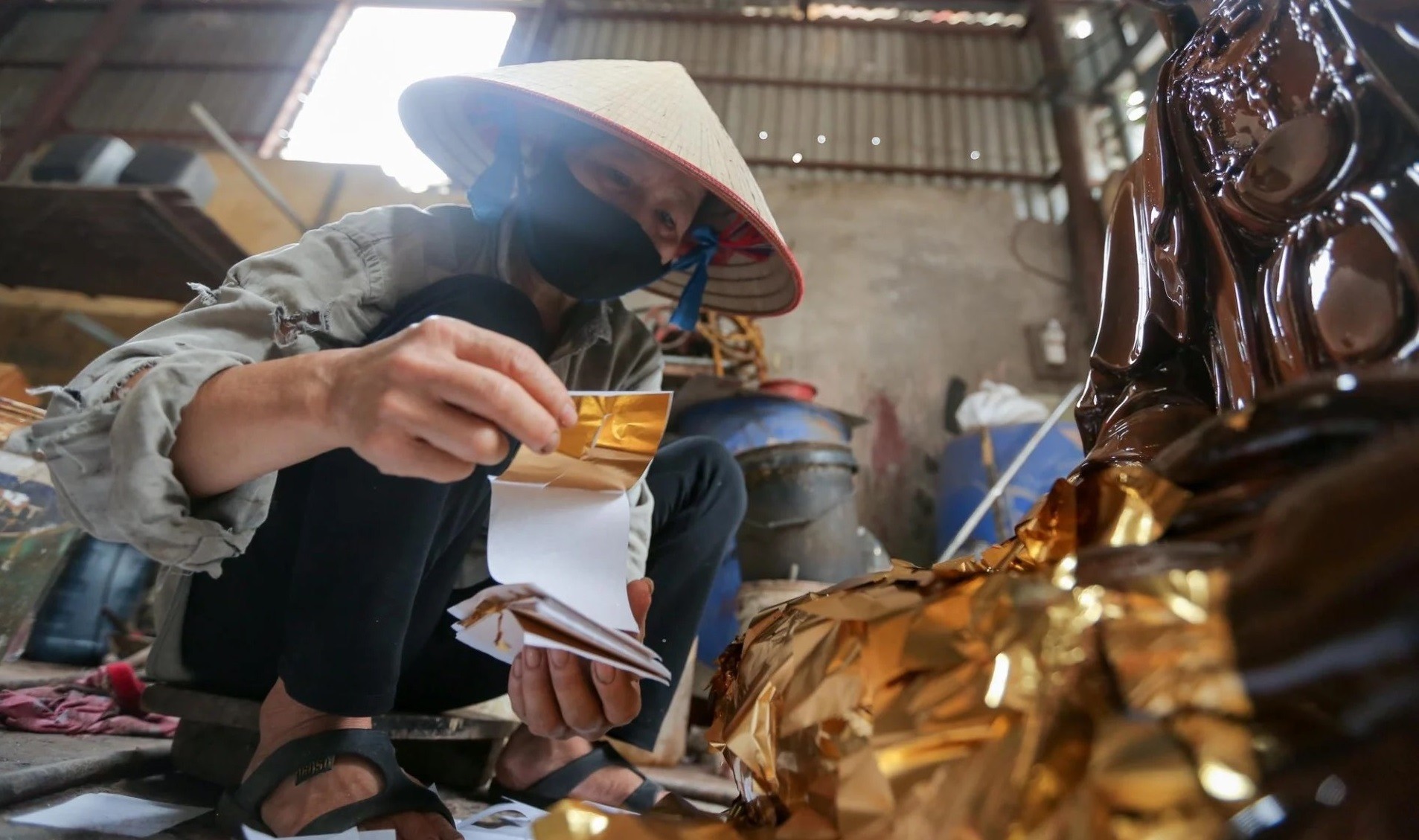 Công đoạn cuối cùng là dát vàng. Theo anh Lợi, việc dát vàng cho tượng được thực hiện qua 14 công đoạn như: đập bóc giấy, lướt quỳ mới, đập giấy vỡ, cắt dòng nong quỳ… Mỗi công đoạn đó lại có nhiều khâu nhỏ hơn, tính tổng lên tới hơn 40 công đoạn lớn nhỏ khác nhau để cho ra thành phẩm, do đó đòi hỏi người thợ sự kiên trì, tỉ mỉ với những thao tác kỹ thuật cao. Công đoạn cuối cùng là dát vàng. Theo anh Lợi, việc dát vàng cho tượng được thực hiện qua 14 công đoạn như: đập bóc giấy, lướt quỳ mới, đập giấy vỡ, cắt dòng nong quỳ… Mỗi công đoạn đó lại có nhiều khâu nhỏ hơn, tính tổng lên tới hơn 40 công đoạn lớn nhỏ khác nhau để cho ra thành phẩm, do đó đòi hỏi người thợ sự kiên trì, tỉ mỉ với những thao tác kỹ thuật cao.