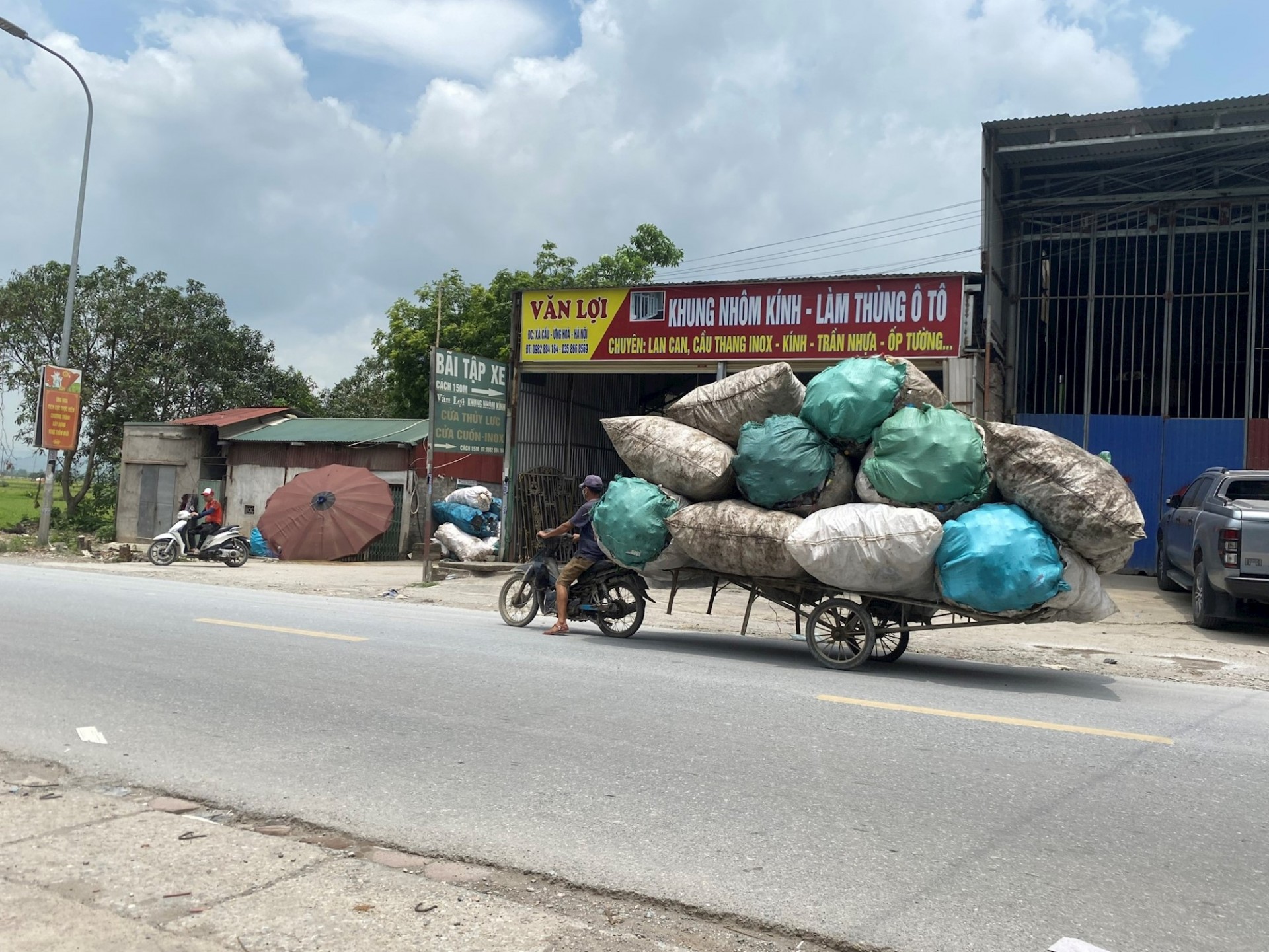 Người đi xe máy kéo theo Nhiều nguy hiểm tiềm ẩn ở làng nghề thu gom, tái chế phế liệu Xà Cầu