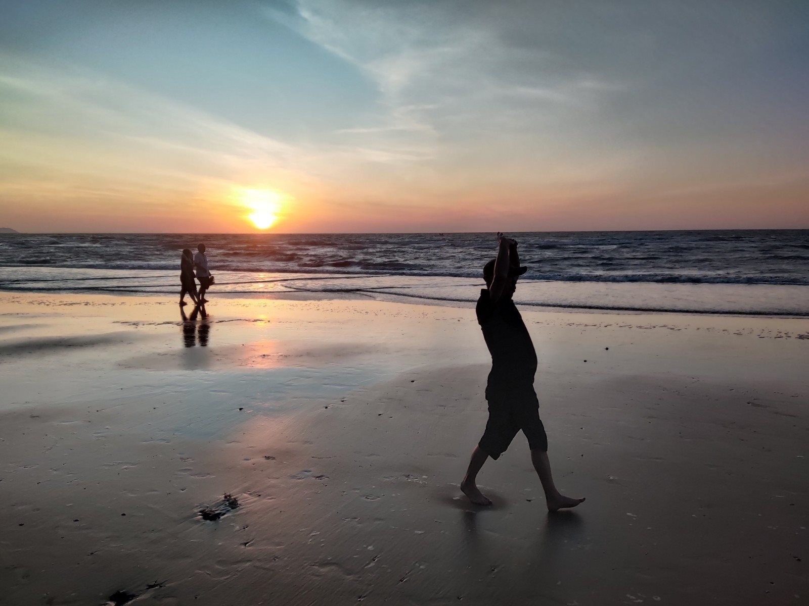 Một vài người dân bản địa đi tập thể dục, tranh thủ đón ánh mặt trời ban mai trên bãi biển vắng người.