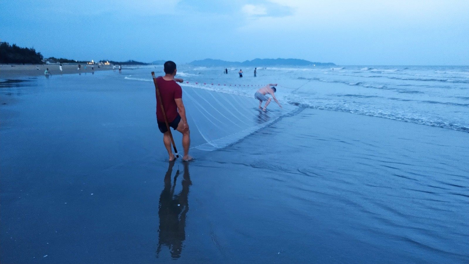 Trời sáng rõ hơn, những ngư dân đang cùng nhau kéo mẻ lưới bắt cá gần bờ.