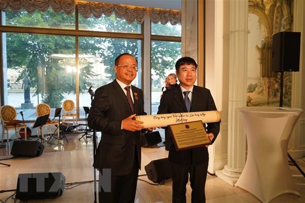 Chủ tịch Hội Người Việt Nam tại LB Nga Đỗ Xuân Hoàng (bên trái) trao bản gốc tờ báo Sự thật số ra ngày 27/1/2024 cho đại diện Cục Lưu trữ Văn phòng Trung ương Đảng Cộng sản Việt Nam - Ảnh: TTXVN