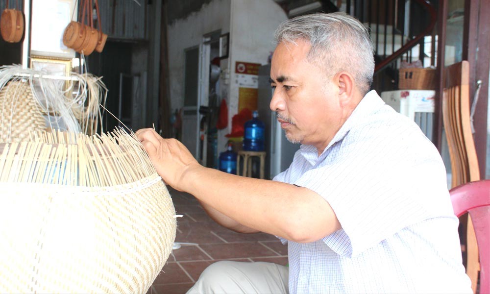 Nghệ nhân ưu tú Nguyễn Văn Tĩnh, GĐ Công ty TNHH mây tre đan Việt Quang thực hiện những công đoạn cuối cùng của sản phẩm