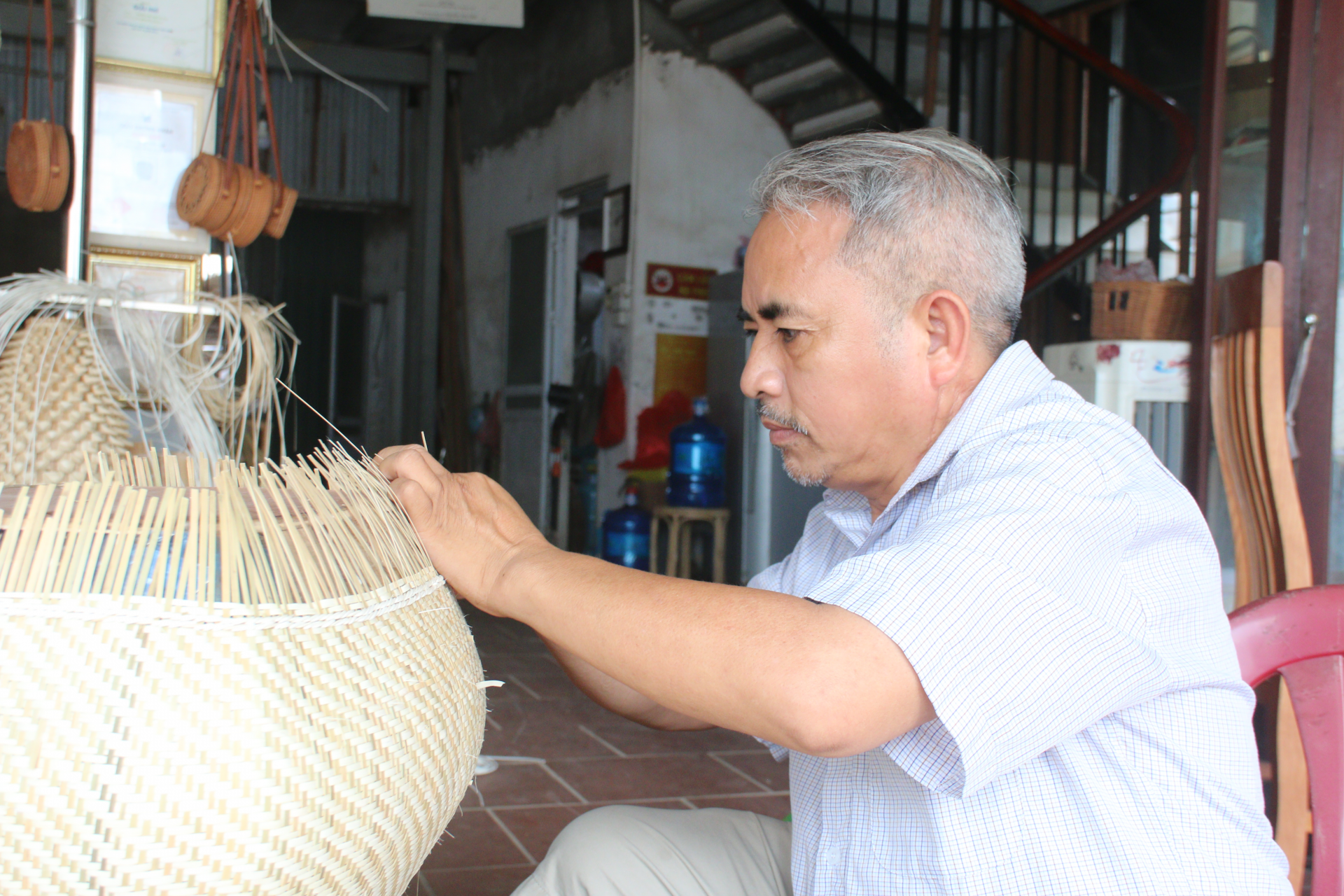 Nghệ nhân ưu tú Nguyễn Văn Tĩnh, Giám đốc Công ty TNHH mây tre đan Việt Quang đang thực hiện những công đoạn cuối cùng của sản phẩm