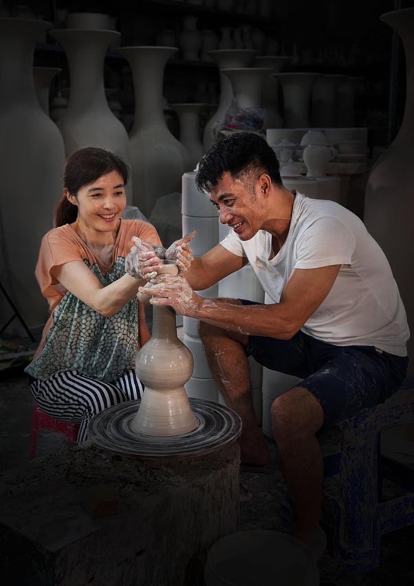 Nữ du khách Nhật Bản được Nghệ nhân Phạm Nguyên (bên phải) hướng dẫn tạo hình gốm thủ công