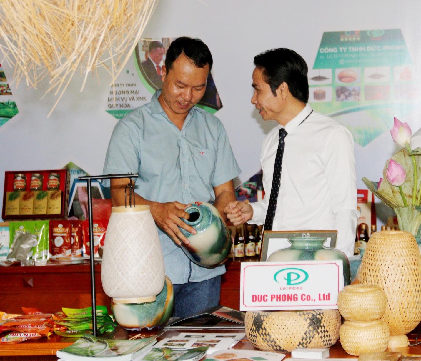 Ông Trần Đức Tân, chủ cơ sở sản xuất gốm sứ Tân Thịnh (áo trắng) đang giới thiệu với khách hàng sản phẩm OCOP vừa được cấp chứng nhận 5 sao cấp Quốc gia. 