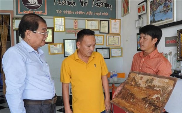 Họa sĩ Lê Hoàng Nhân giới thiệu tranh vỏ tràm cho khách. Ảnh: Văn Sĩ - TTXVN Họa sĩ Lê Hoàng Nhân giới thiệu tranh vỏ tràm cho khách. Ảnh: Văn Sĩ - TTXVN