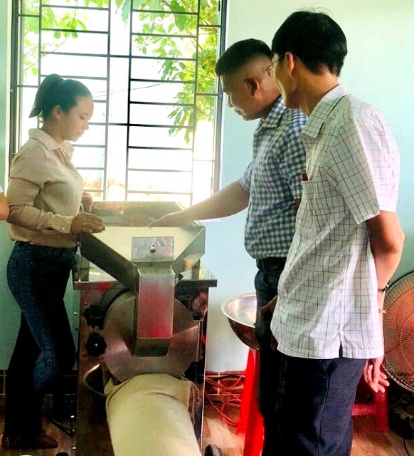 Đại diện Cơ sở Sản xuất và kinh doanh nông sản Khánh Giang (bìa trái) giới thiệu về hiệu quả ứng dụng máy móc thiết bị trong sản xuất ngũ cốc các loại