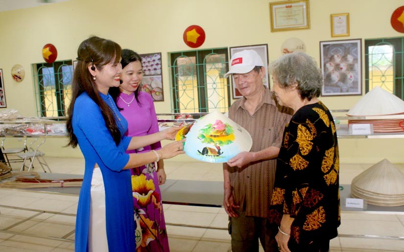Hướng dẫn viên đang giới thiệu, quảng bá sản phẩm nón lá đến với du khách tại Khu trưng bày sản phẩm nón lá Vĩnh Thịnh.