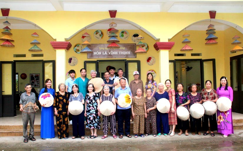 Du khách đến thăm và chụp ảnh lưu niệm tại Khu trưng bày sản phẩm truyền thống nón lá thôn Vĩnh Thịnh, xã Đại Áng.