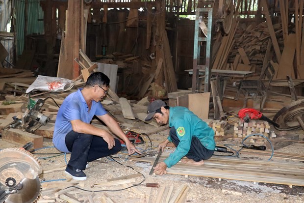 Ông Minh hướng dẫn thợ làm mộc truyền thống tại thôn Bến Đền, xã Trường Sơn (Hà Tĩnh). Ảnh: Hữu Quyết - TTXVN