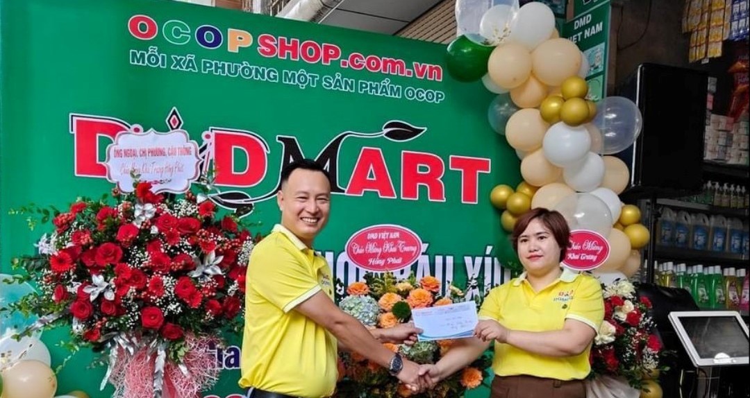 Ông Phạm Ngọc Thể thay mặt tập đoàn trao Chứng nhận đại lý OCOPShop DMDMart cấp 1 cho bà Triệu Thị Thảo Ông Phạm Ngọc Thể thay mặt tập đoàn trao Chứng nhận đại lý OCOPShop DMDMart cấp 1 cho bà Triệu Thị Thảo