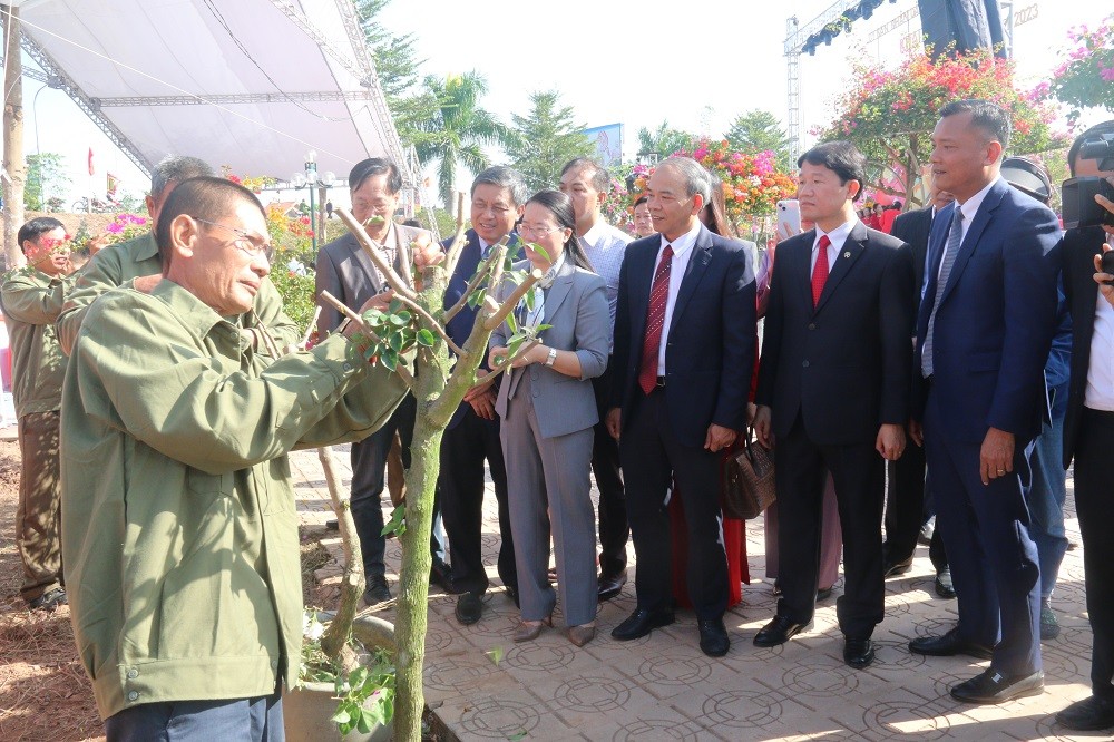 Các đại biểu xem các nghệ nhân trình diễn cắt, tỉa hoa giấy Các đại biểu xem các nghệ nhân trình diễn cắt, tỉa hoa giấy