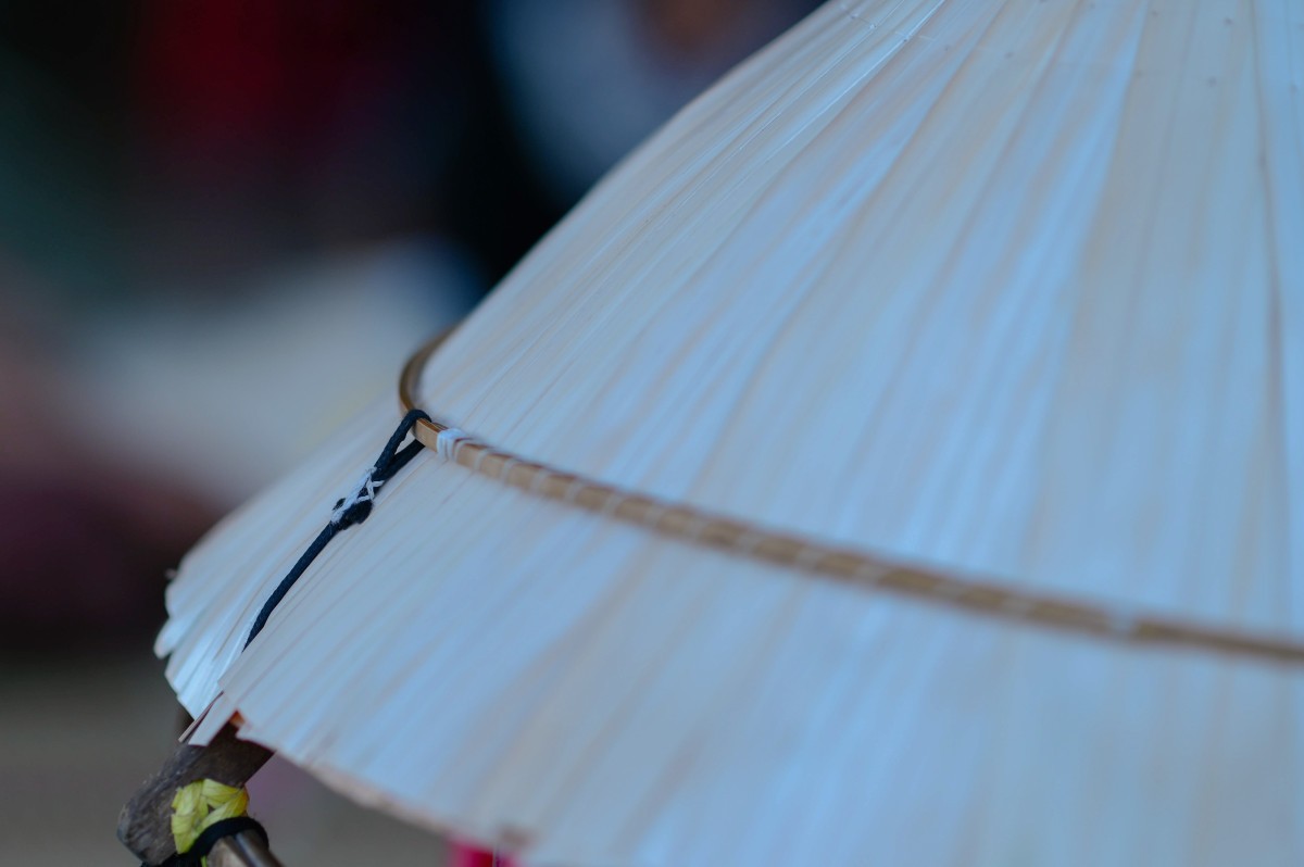 Người thợ dùng vành chụp lên bên ngoài mô nón để giữ cho lá nằm cố định. Điều này giúp người thợ chằm nón được dễ dàng Người thợ dùng vành chụp lên bên ngoài mô nón để giữ cho lá nằm cố định. Điều này giúp người thợ chằm nón được dễ dàng