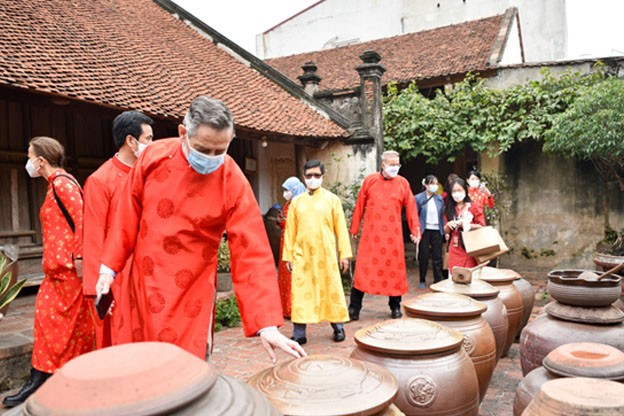 Du khách nước ngoài trải nghiệm Làng cổ Đường Lâm.” Ảnh: Bảo Chung