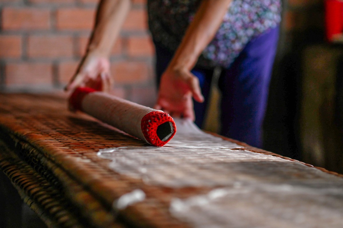 Sau đó, từng chiếc bánh được trải đều ra cái phên bánh bằng đôi bàn tay khéo léo của người thợ