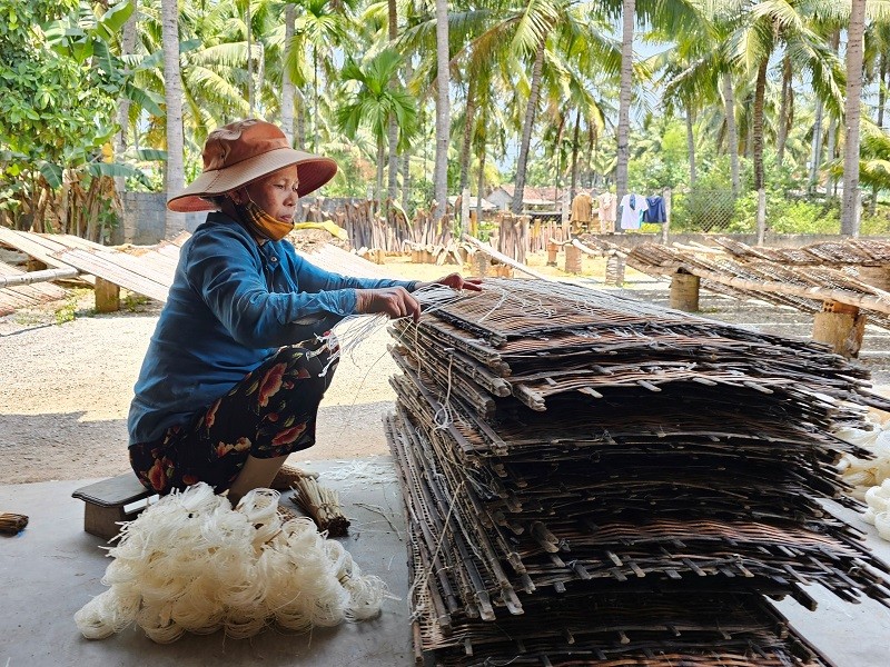 Bún phơi vừa khô, người thợ liền chồng nhiều vỉ lại 1 lần và mang vào nhà dùng tay gỡ bún ra khỏi vỉ