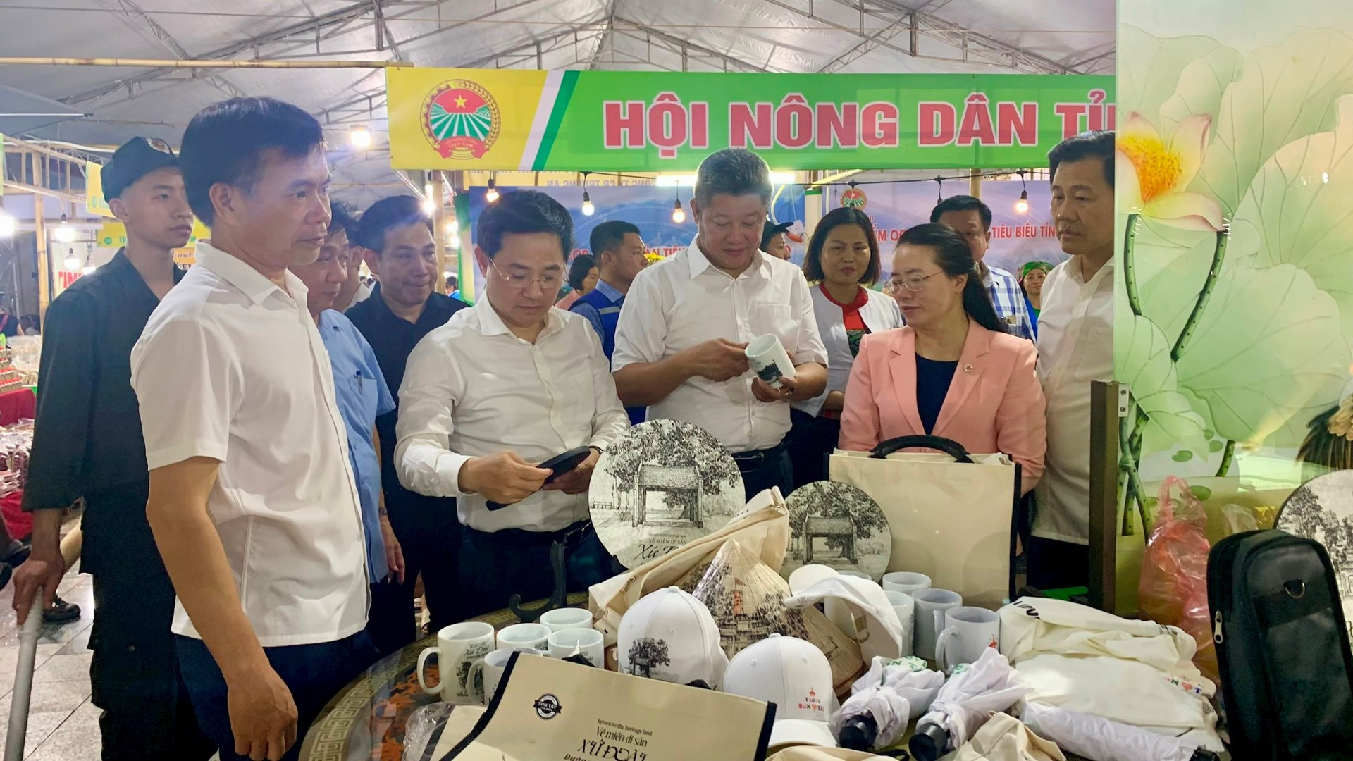 Lãnh đạo Thành phố Hà Nội, Thị xã Sơn Tây và các sở, ngành tham quan gian hàng trưng bày sản phẩm OCOP tại sự kiện. (Ảnh: Ánh Dương).