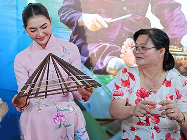 Hoa Hậu truyền thông Thu Uyên quan sát nghệ nhân làm nón lá Gò Găng.
