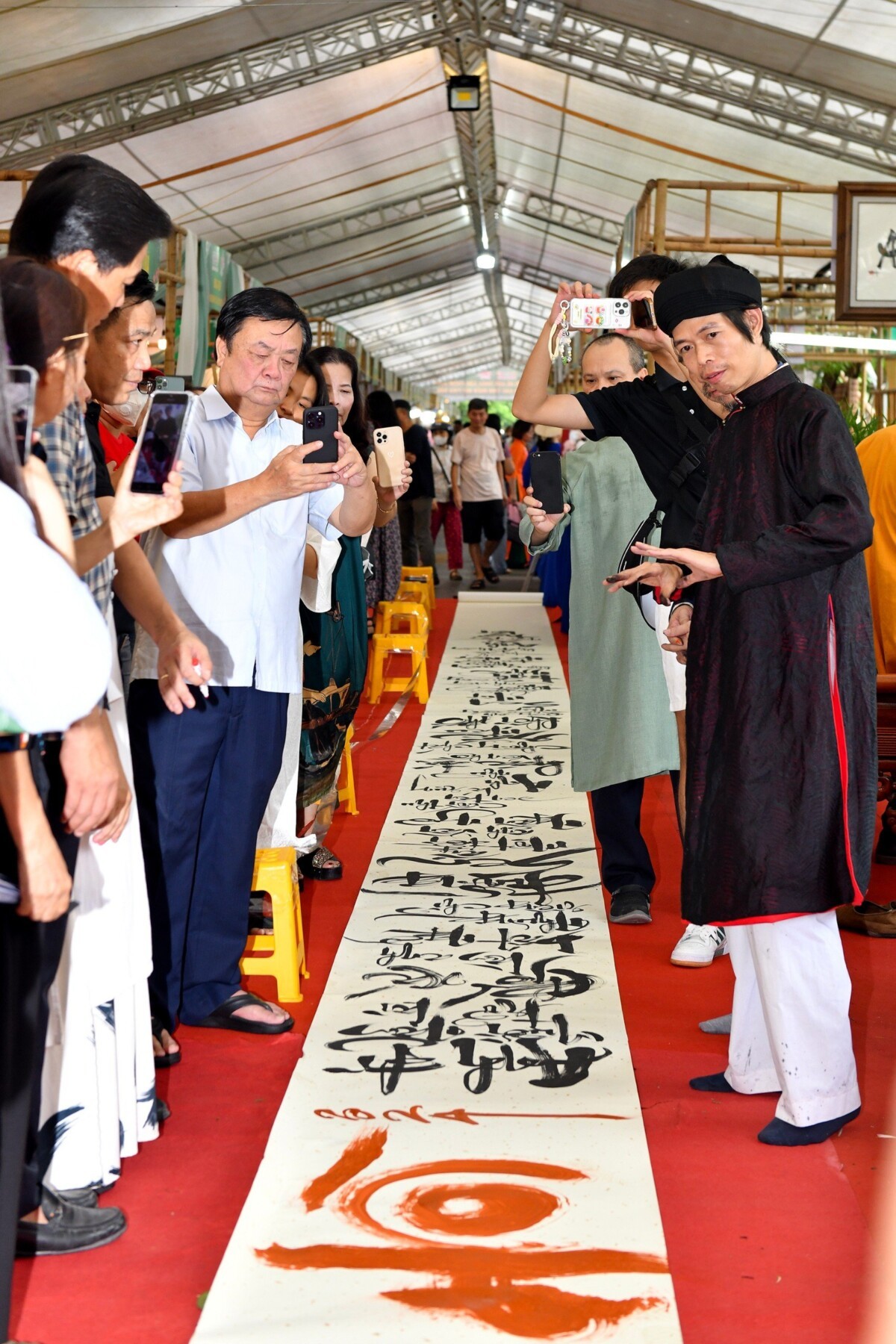 Bộ trưởng Lê Minh Hoan trải nghiệm hoạt động viết bức thư pháp dài 70m tại Không gian văn hóa Trà Việt