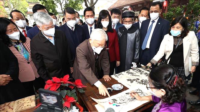 Tổng Bí thư Nguyễn Phú Trọng xem in tranh dân gian Đông Hồ tại Di tích lịch sử-văn hóa Đền Đô ở khu phố Thượng, phường Đình Bảng, thành phố Từ Sơn, tỉnh Bắc Ninh (24/1/2022)