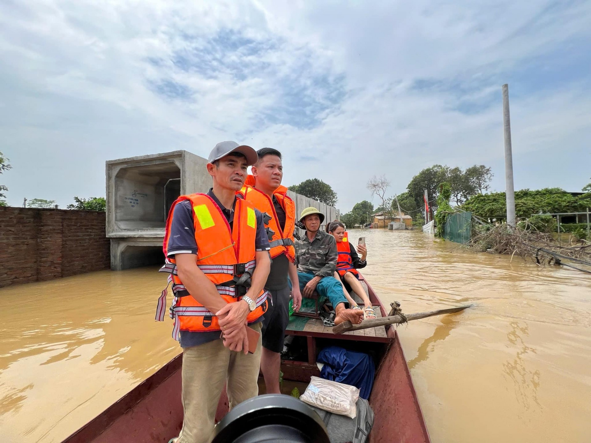 Ông Lê Văn Tám (bên trái) cùng các thành viên ứng cứu xưởng sản xuất khi nước dâng cao bất ngờ.