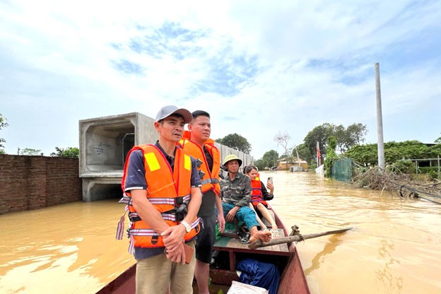 Ông Lê Văn Tám (bên trái) cùng các thành viên ứng cứu xưởng sản xuất khi nước dâng cao bất ngờ. Ông Lê Văn Tám (bên trái) cùng các thành viên ứng cứu xưởng sản xuất khi nước dâng cao bất ngờ.