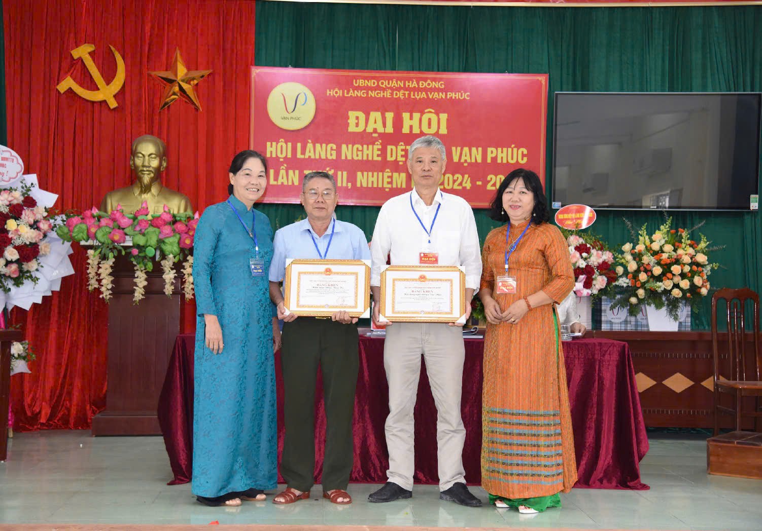 Bà Hà Thị Vinh thừa uỷ quyền trao Bằng khen của Chủ tịch UBND thành phố Hà Nội cho Hội làng nghề dệt lụa Vạn Phúc và nguyên Chủ tịch Hội làng nghề dệt lụa Vạn Phúc Phạm Khắc Hà.