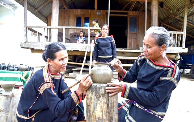 Các nghệ nhân buôn Dơng Bắk tạo hoa văn cho gốm ở làng gốm cổ Yang Tao.