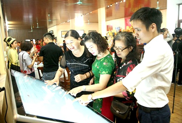 Du khách trải nghiệm ứng dụng du lịch thông minh tại Trung tâm Thông tin du lịch làng nghề Bát Tràng (Hà Nội).