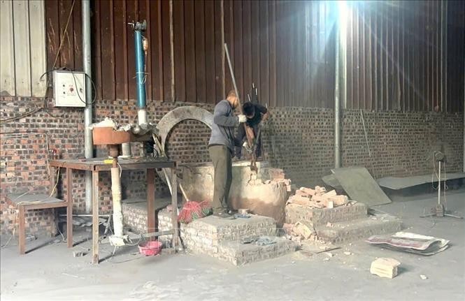 Người dân tại Văn Môn phá dỡ lò cô đúc nhôm. Ảnh: Thanh Thương/TTXVN