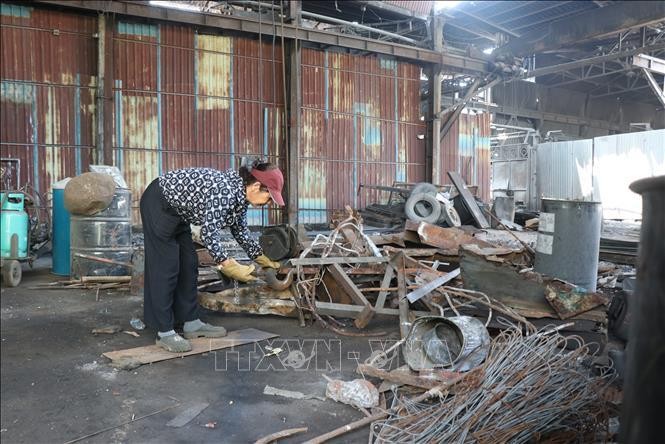 Người dân thu dọn nguyên liệu tại cụm công nghiệp Châu Khê, thành phố Từ Sơn sau khi dừng hoạt động. Ảnh: Thanh Thương/TTXVN