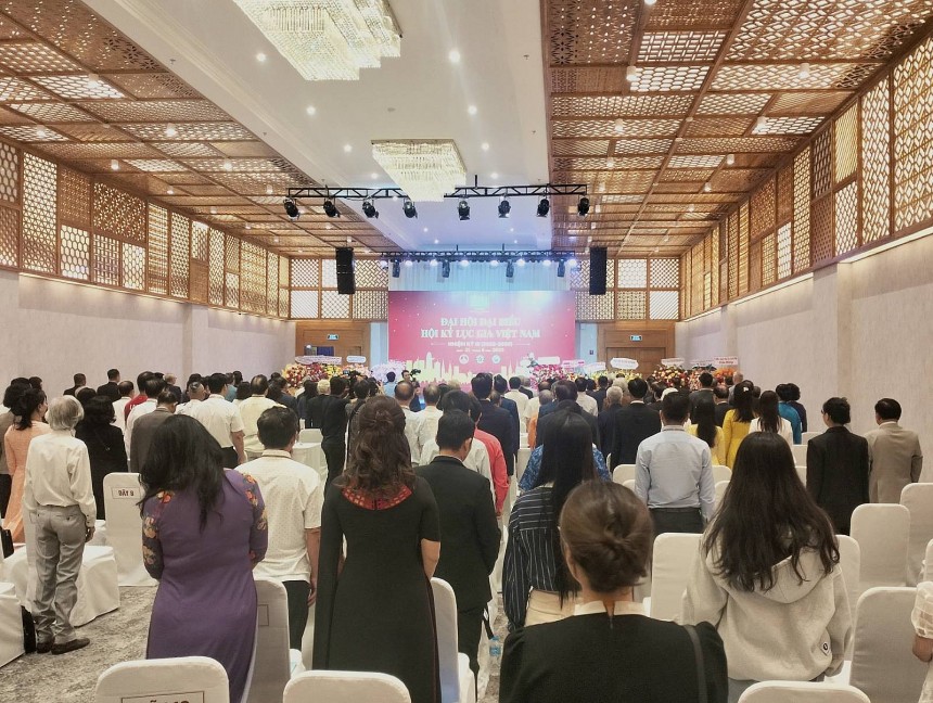 Các đại biểu tham dự thực hiện nghi thức chào cờ, hát Quốc ca và dành một phút mặc niệm tưởng nhớ ông Lê Trần Trường An - người sáng lập kiêm Tổng Thư ký Tổ chức Kỷ lục Việt Nam (VietKings), Tổng Thư ký WorldKings