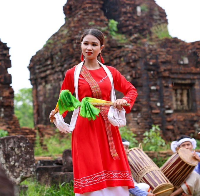 Trang phục truyền thống rực rỡ của vũ công Chăm nổi bật trên nền gạch cổ kính, tạo nên sự tương phản độc đáo. Trang phục truyền thống rực rỡ của vũ công Chăm nổi bật trên nền gạch cổ kính, tạo nên sự tương phản độc đáo.