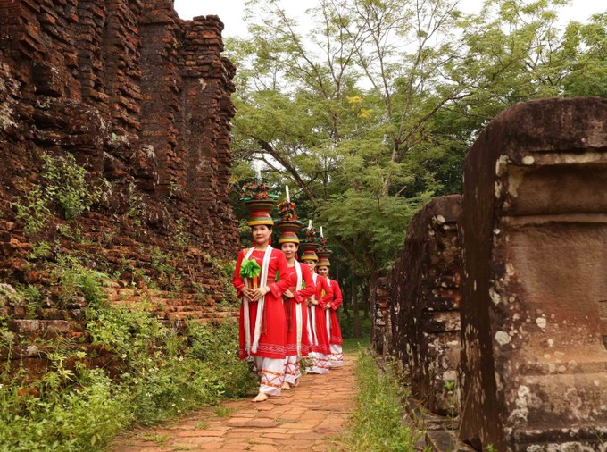 Trang phục truyền thống rực rỡ của vũ công Chăm nổi bật trên nền gạch cổ kính, tạo nên sự tương phản độc đáo. Trang phục truyền thống rực rỡ của vũ công Chăm nổi bật trên nền gạch cổ kính, tạo nên sự tương phản độc đáo.