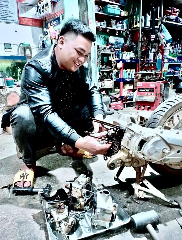 Nguyễn văn Bính đang sửa xe máy cho khách 