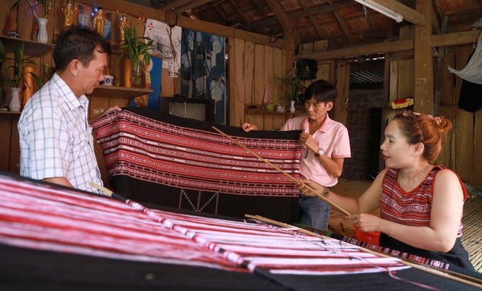 Nghệ nhân dệt thổ cẩm ở Xí Thoại giới thiệu cho du khách về hoa văn thổ cẩm.