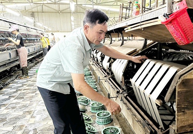 Ông Nguyễn Duy Đông, Giám đốc nhà máy đang kiểm tra chất lượng tơ tại nhà máy. Ảnh: Từ Huy
