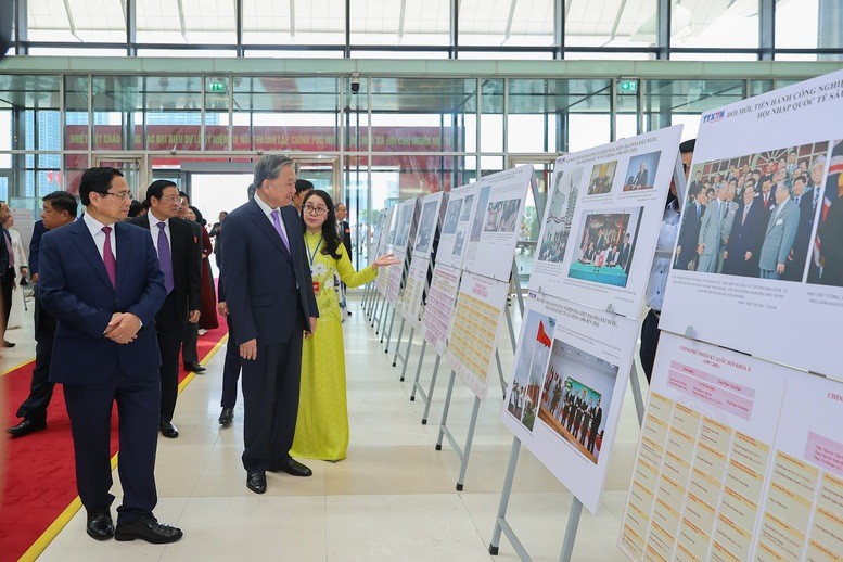 Tổng Bí thư Tô Lâm và Thủ tướng Phạm Minh Chính cùng các đại biểu tham quan trưng bày ảnh về hoạt động của Chính phủ qua các thời kỳ - Ảnh: VGP/Nhật Bắc