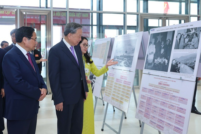 Tổng Bí thư Tô Lâm và Thủ tướng Phạm Minh Chính cùng các đại biểu tham quan trưng bày ảnh về hoạt động của Chính phủ qua các thời kỳ - Ảnh: VGP/Nhật Bắc