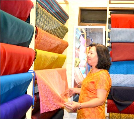 Bà Trần Thị Ngọc Lan, Phó chủ tịch Hội Làng nghề dệt lụa Vạn Phúc  với các sản phẩm của làng nghề. 