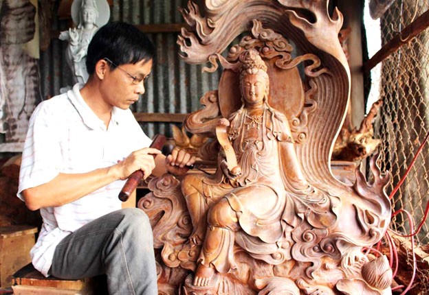 Nghệ nhân đang chạm khắc gỗ tại làng nghề mộc Chợ Thủ, tỉnh An Giang