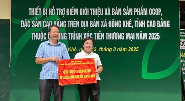 Lãnh đạo Trung tâm Khuyến công và Xúc tiến thương mại tỉnh bàn giao thiết bị hỗ trợ điểm giới thiệu sản phẩm cho chủ kinh doanh Nông Thị Hoa.