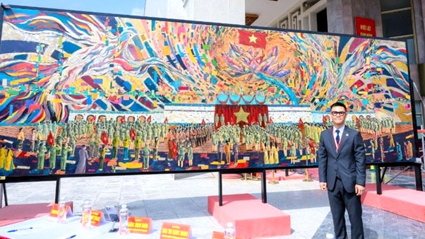 Họa sĩ Chu Nhật Quang bên bức tranh sơn mài Kỷ lục Guinness thế giới “Bác Hồ đọc Tuyên ngôn Độc lập”./Ảnh Hoài Thu