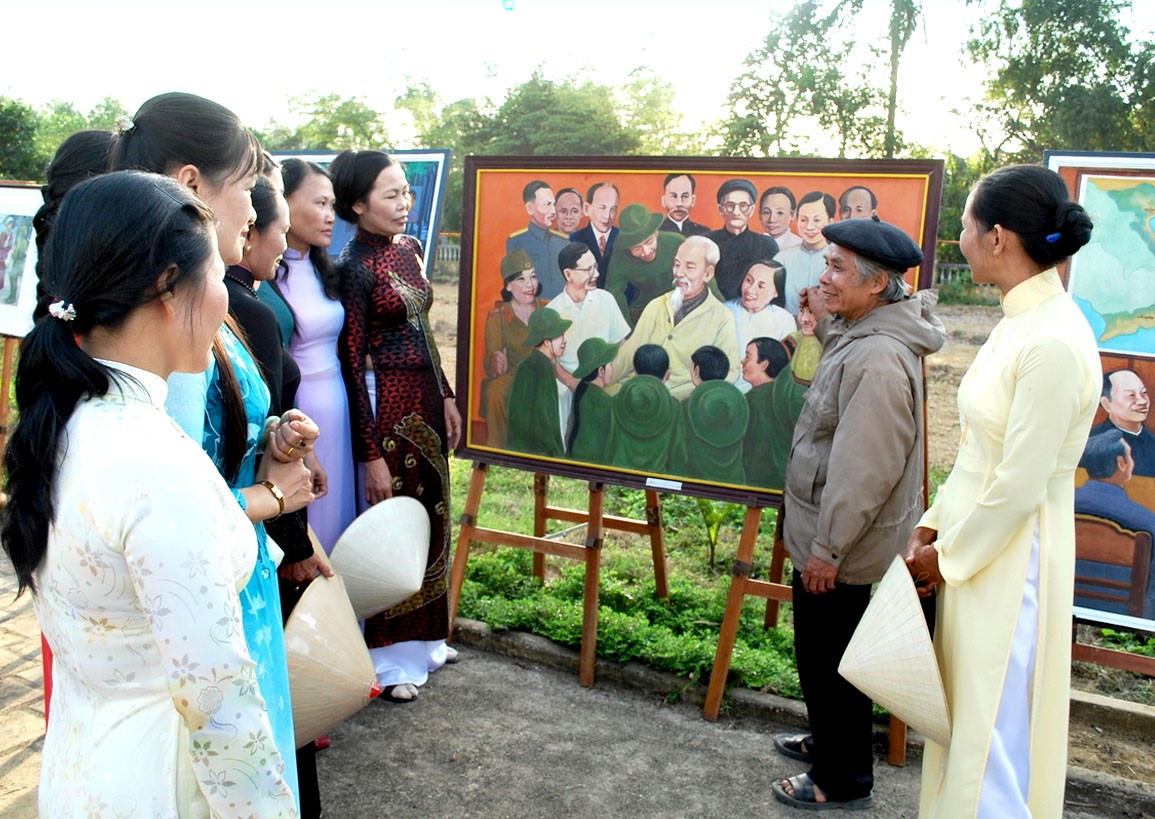 Cố họa sĩ thuyết trình tác phẩm“Bác Hồ với đất Quảng” cho các phụ nữ nghe.