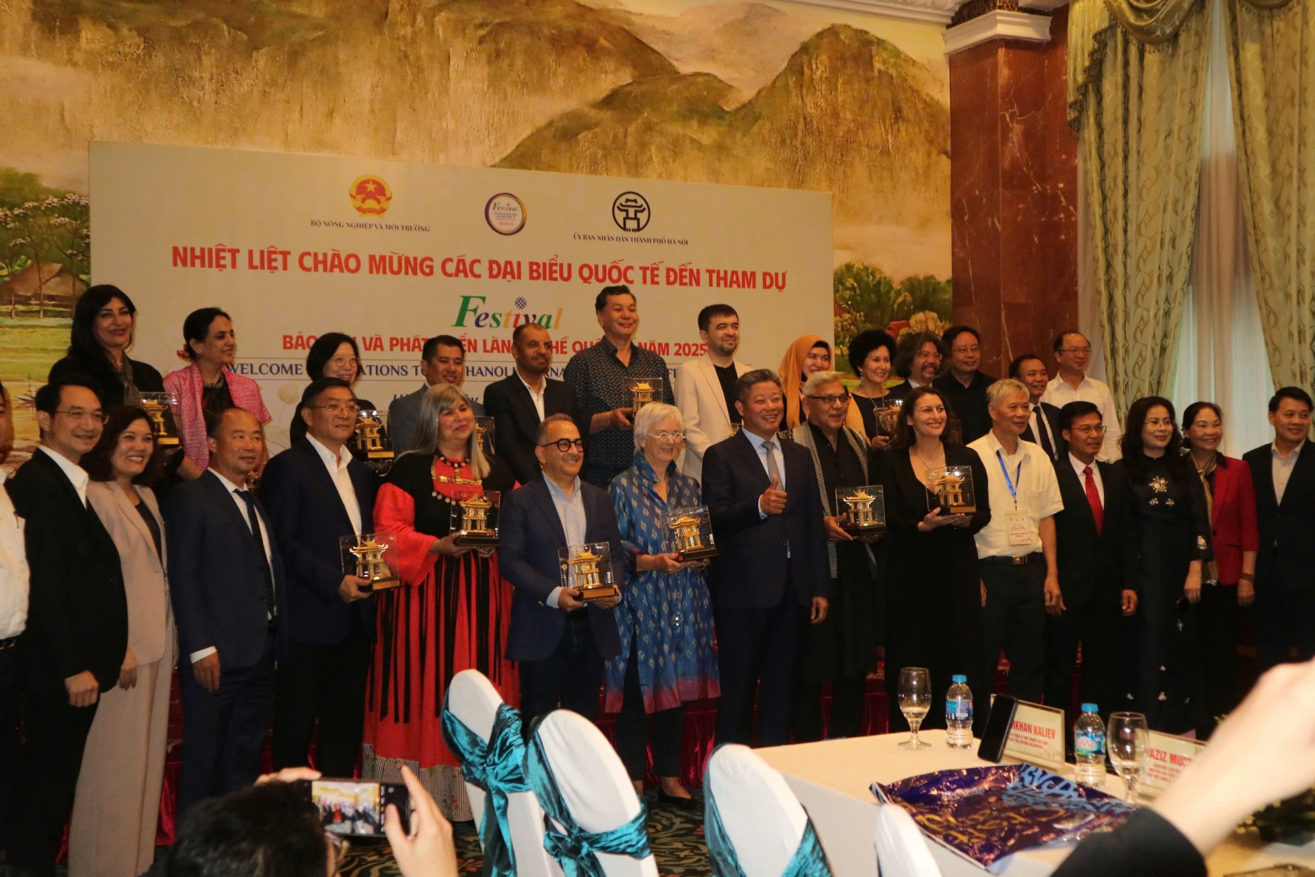 Phó chủ tịch UBND TP Hà Nội Nguyễn Mạnh Quyền cùng Hội đồng Thủ công thế giới và đoàn khách quốc tế chụp ảnh lưu niệm.