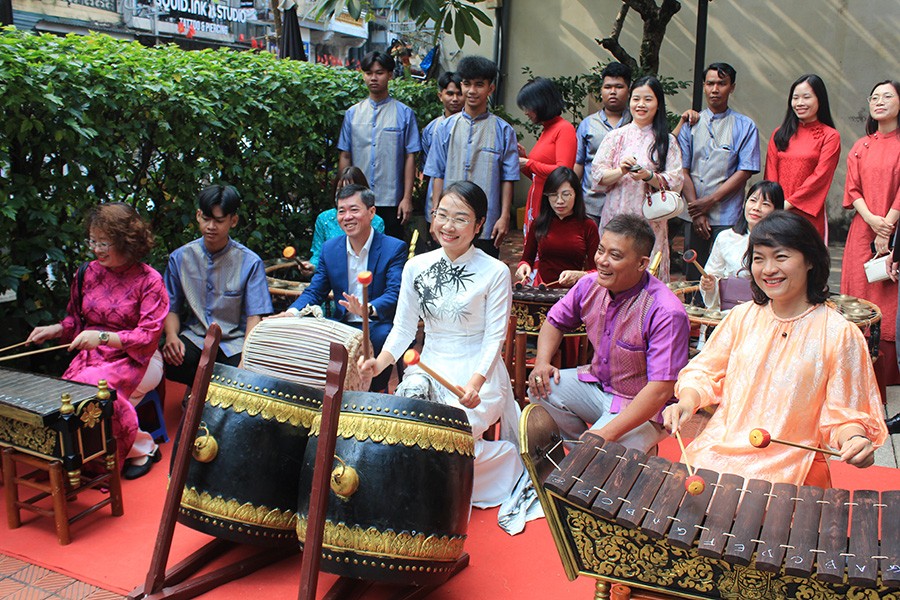 Nghệ nhân Thạch Anh Xuân (áo tím) hướng dẫn du khách trải nghiệm nhạc ngũ âm Khmer. Ảnh: TITC