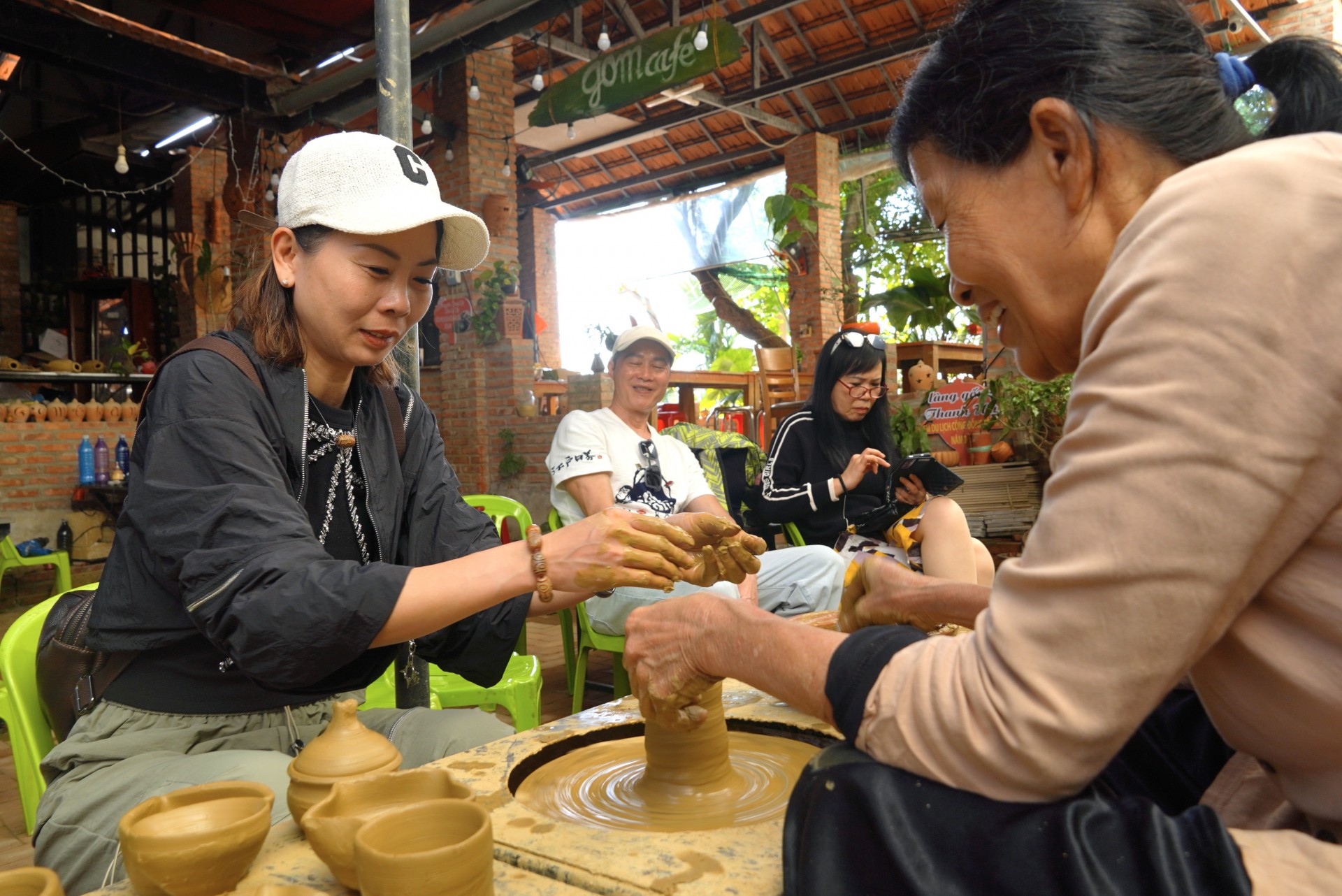 Du khách hào hứng trải nghiệm nhào nặn gốm tại làng gốm Thanh Hà.