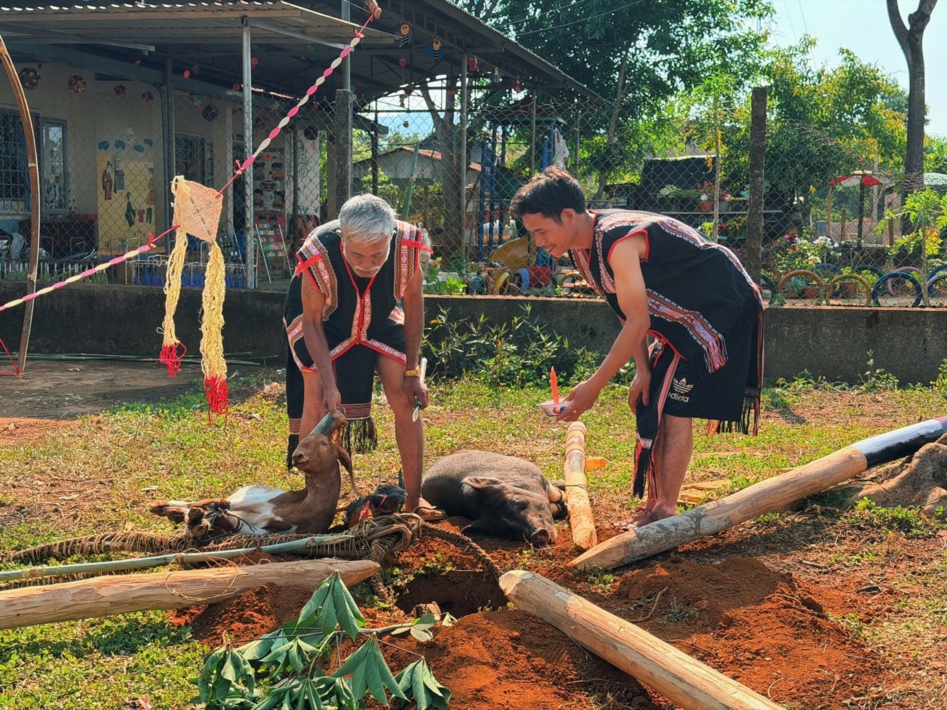 Ảnh 2: Hội đồng già làng thực hiện nghi thức cúng, khấn trước khi dựng cây nêu.